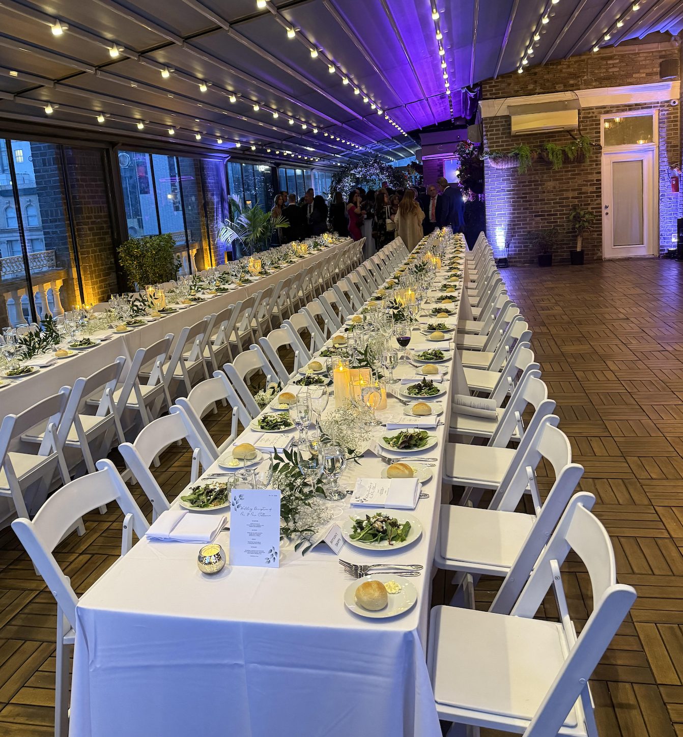 Long banquet tables set for a wedding dinner on the Terrace